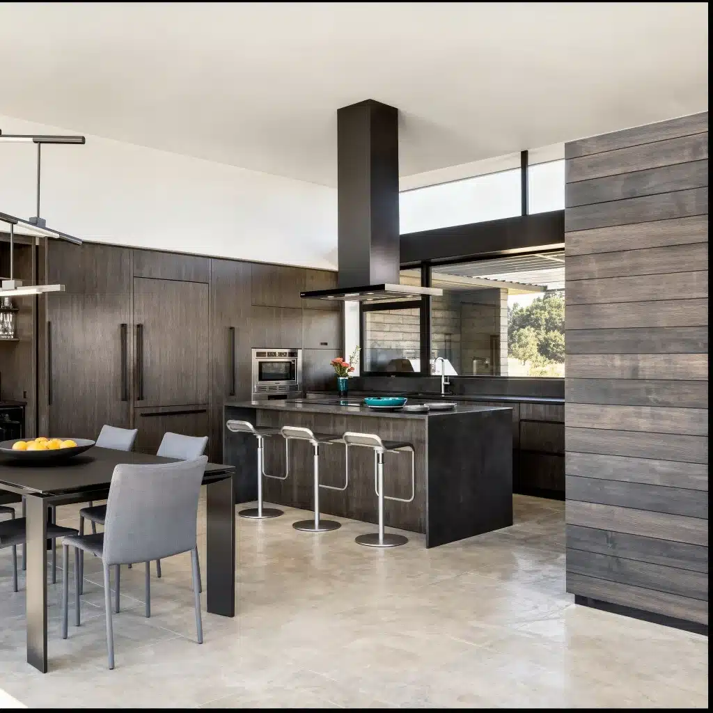 Modern kitchen with dark wood cabinets, central island, bar stools, and dining table.